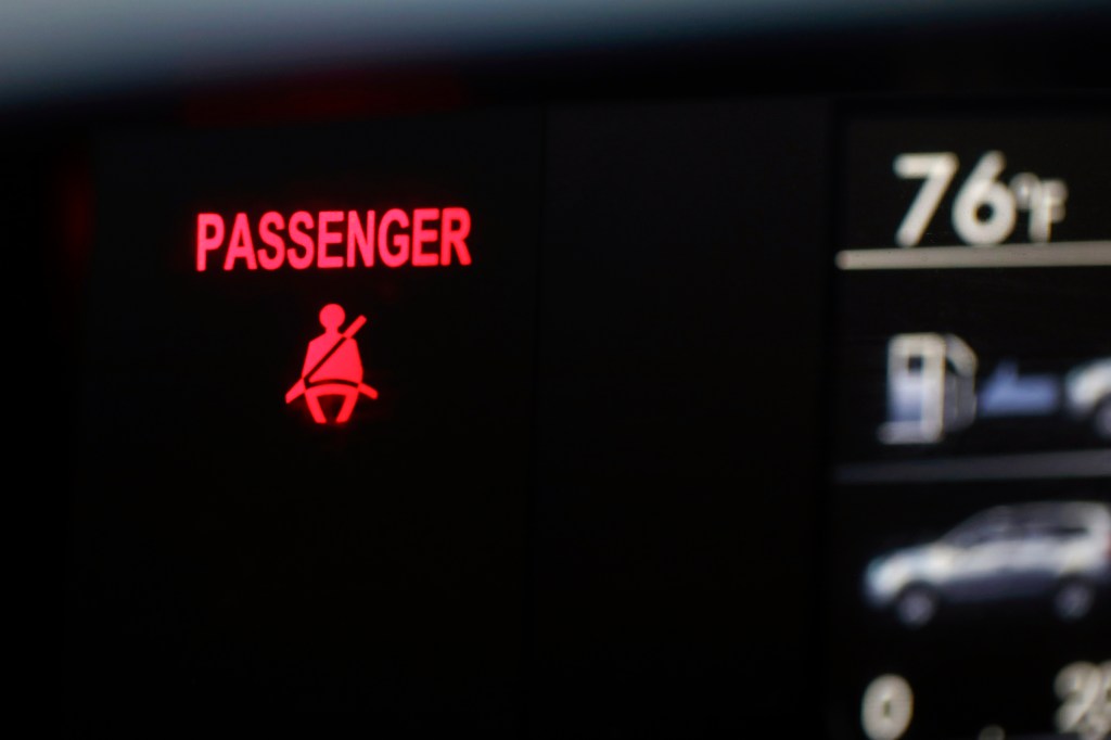 A seat belt warning sign for the right front passenger seat is displayed on a vehicle Monday, Aug. 21, 2023.